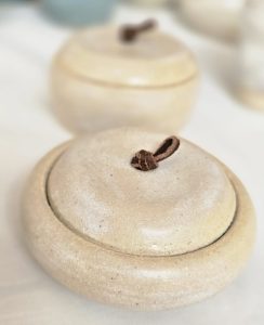 Lidded pot in cream colour with chocolate suede handle